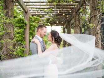 Bride and groom hugging, the bride's veil blowing in the wind, Kaitlyn Ferris photo